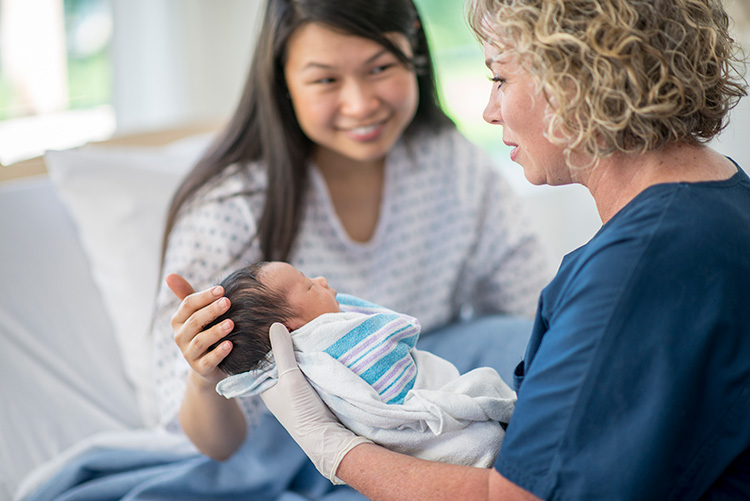 A healthcare provider handing a mother her baby