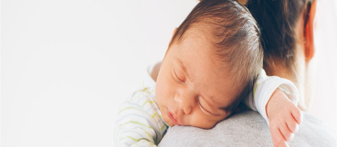 Baby sleeping on a parent's shoulder