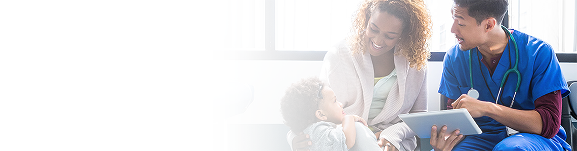 A doctor talks with a mom and a young toddler about information on a tablet device