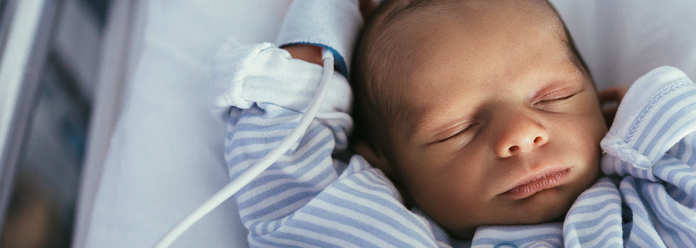 premature infant sleeping in a hospital bed