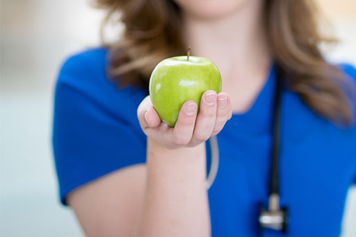 Nurse holding a Granny Smith apple