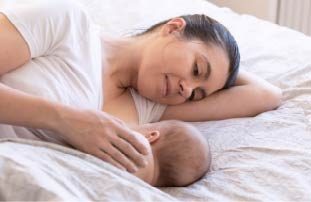 Mother breastfeeding baby in the lying down position Breastfeeding Education: Tips & Techniques for Getting Started