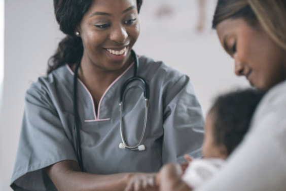 Mother holding baby while chatting with female doctor