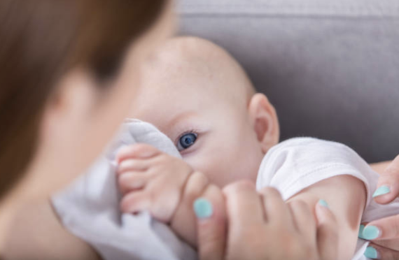 Baby looking up at mother while breastfeeding